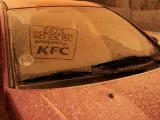 Logo de KFC dibujado en un coche 'rebozado' por el polvo sahariano.