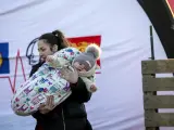 Una mujer sostiene a un bebé en un campo de refugiados ucraniano en Moldavia.