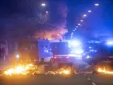 Cubos de basura ardiendo en Malmö frente a la Policía en los disturbios por la concentración del partido de ultraderechista Stram Kurs.