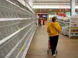 Una mujer camina en un supermercado con estantes vacíos en Moscú.