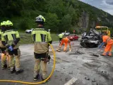 Operarios realizan labores de limpieza ante la mirada de los bomberos.