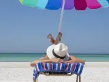 Una persona tomando el sol en la playa.