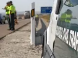 Imagen de archivo de un furgón de la Guardia Civil de Tráfico y dos agentes junto a la carretera.