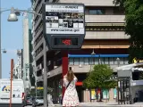 Una mujer hace una fotografía a un termómetro en la calle que marca 49 grados, a 12 de julio de 2022, en Orense, Galicia (España).