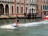 Dos jóvenes haciendo esquí náutico en los canales de Venecia.
