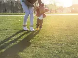 Una madre ayuda a caminar a su hija