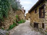 Narrow alley in an old medieval town made of stone in the Sierra de Madrid. Horcajuelo. Spain.