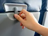 Persona cerrando la mesa del avi&oacute;n.