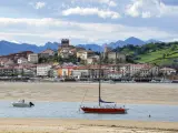 San Vicente de la Barquera, Cantabria, Spain - October 30, 2010: Yachts and fishing boats in the closed bay of the Cantabrian Sea against the backdrop of the mountains and the city of San Vicente de la Barquera, Cantabria, Northern Spain