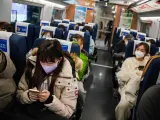 Pasajeros con mascarillas en un tren de la estación sur de Pekín en la víspera de Año Nuevo.