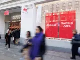 Varias personas caminan frente a una tienda de ropa en la Gran V&iacute;a de Madrid.