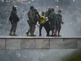 Varios policías tratan de contener a los radicales que asaltaron las instituciones en Brasilia.