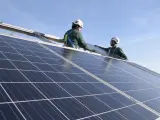 Dos operarios instalan placas solares.