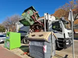 Un camión de la basura recoge un contenedor.