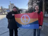 Yuri Scheliazhenko, a la izquierda y Serhii Ustymenki muestran una bandera del Movimiento Pacifista e Ucrania en el centro de Kiev.