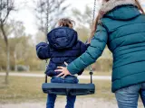 Una mujer cuidando de una niña en un parque, en una imagen de archivo.