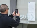 Un cliente toma una foto del aviso de la FDIC a los clientes del SVB.