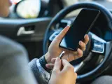 Una persona cargando su tel&eacute;fono m&oacute;vil en el coche.