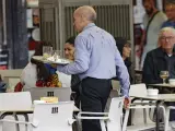 Un camarero porta una bandeja en una terraza de un bar de Madrid
