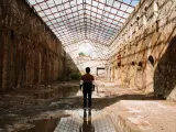 Silhouette of a young man and reflection inside an abandoned industrial building