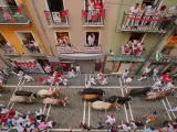 Mozos perseguidos por toros de la ganadería extremeña Jandilla, en el tramo que va desde la curva de Mercaderes al inicio de Estafeta, durante el sexto encierro de Sanfermines 2023.