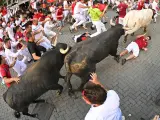 Un mozo tumbado tras caerse por el empellón de uno de los toros de Miura, en el último encierro de San Fermín 2023.