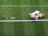 Carlos Alcaraz tendido en la hierba celebrando su victoria en Wimbledon.