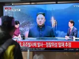 Un hombre mira una pantalla de televisión que muestra un noticiario con imágenes de archivo del líder de Corea del Norte, Kim Jong Un, en la estación de tren de Seúl.