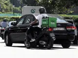 Un repartidor de la empresa de comida a domicilio, Uber Eats, circula con su moto por una calle de Madrid