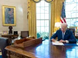 Joe Biden firma un ley en el despacho oval de la Casa Blanca.