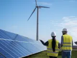 Dos operarios en una planta solar y eólica.