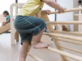 Un niño jugando con mobiliario de juego infantil.