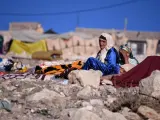 Una mujer llora sentada entre los escombros provocados por el terremoto, a 10 de septiembre de 2023, en Moulay Brahim, provincia de Al Haouz (Marruecos).