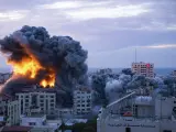 Una columna de fuego y humo emerge entre unos edificios de la ciudad de Gaza, en un ataque aéreo israelí en respuesta al bombardeo de Hamás.