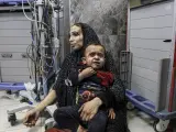 Una madre y su hijo esperan en el suelo para ser atendidos en el hospital de al-Shifa.