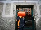 Un repartidor de bombonas de butano carga con una bombona, a 21 de noviembre de 2023, en Lugo, Galicia (España).