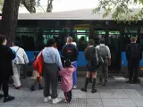Varias personas delante de un bus de la EMT en el barrio de Puente de Vallecas, a 27 de septiembre de 2023, en Madrid