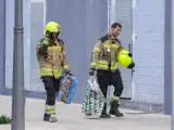 Dos bomberos, tras recuperar pertenencias de los afectados, entre ellas un juego.