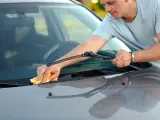 Un conductor cambia las escobillas de su coche.