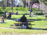 Un hombre comiendo en una mesa de camping