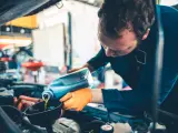 Un mecánico durante el proceso del cambio de aceite de un coche.