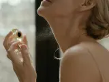 Mujer echándose perfume.