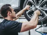 Un mecánico cambiando los neumáticos de un automóvil.