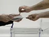 Voto depositado en la urna electoral en el colegio electoral instalado en el Instituto de Educación Continua (UPF) del barrio de L'Eixample de Barcelona.