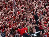 Xabi Alonso se sube a la grada con los aficionados del Leverkusen para recibir el trofeo de campeón.