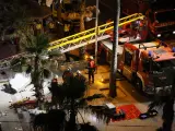 Los bomberos trabajan junto al lugar en el que se ha derrumbado el edificio de un restaurante con terraza elevada, en Palma de Mallorca.