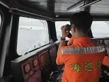En esta foto publicada por la Guardia Costera de Taiwán, un miembro de la Guardia Costera de Taiwán vigila un buque de la armada china que opera cerca del islote de Pengjia, al norte de Taiwán, el jueves 23 de mayo de 2024. Taiwán envió aviones y puso en alerta el jueves a unidades de misiles, navales y terrestres por los ejercicios militares chinos que se están llevando a cabo en torno a la isla.