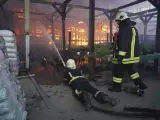 Los bomberos trabajan para apagar las llamas en el hipermercado de Járkov tras un ataque ruso.