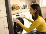 Una mujer poniendo la lavadora.