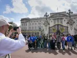 Un grupo de turistas posa para una fotografía frente al Palacio de Buckingham en Londres.